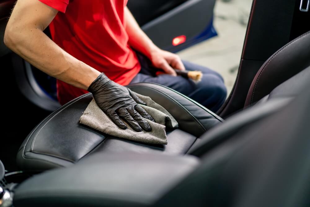 an employee of a car service station performs chemical cleaning.